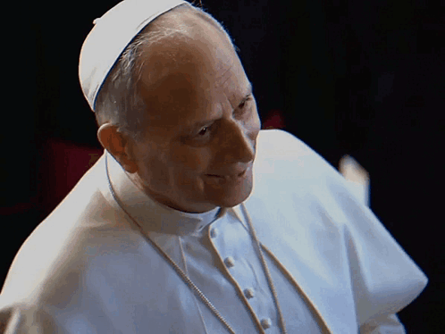 A Man Wearing A White Robe And A White Hat Is Smiling GIF