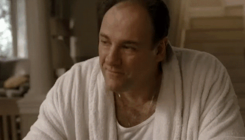 A Man Wearing A White Robe And A White Shirt Is Smiling . GIF