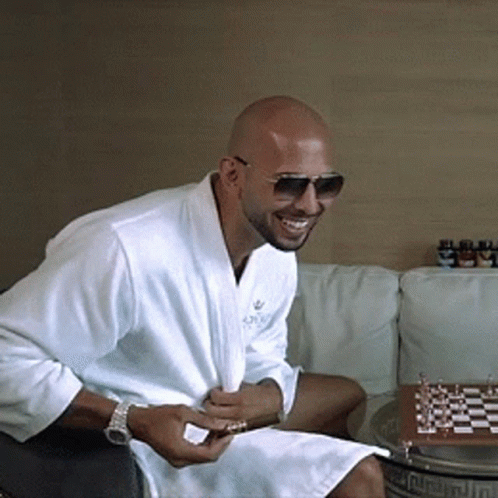 A Man Wearing A White Robe And Sunglasses Is Sitting On A Couch GIF