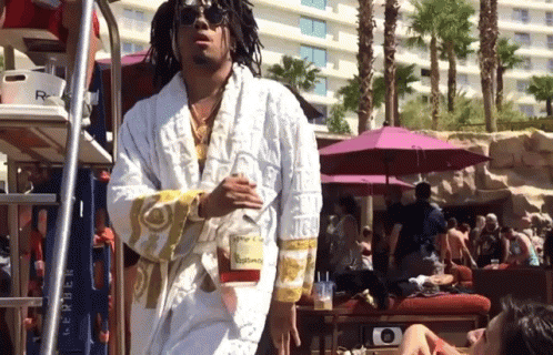 A Man Wearing A White Robe With The Word Versace On The Sleeves GIF