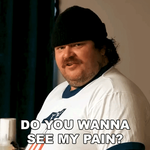 A Man Wearing A White Shirt And A Black Hat Says Do You Wanna See My Pain GIF