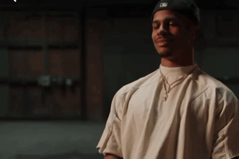A Man Wearing A White Shirt And A Black Hat With A Ny Logo On It GIF