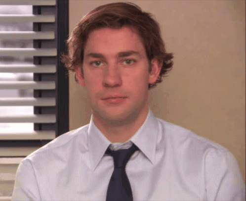 A Man Wearing A White Shirt And A Blue Tie Looks At The Camera GIF