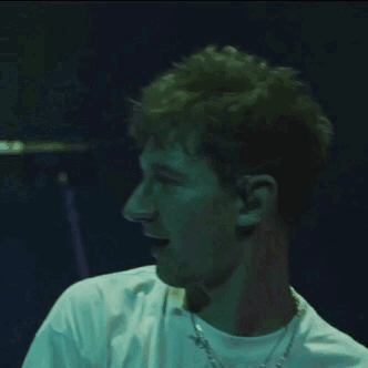 A Man Wearing A White Shirt And A Chain Around His Neck GIF
