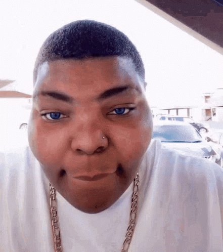 A Man Wearing A White Shirt And A Gold Chain Is Making A Face GIF