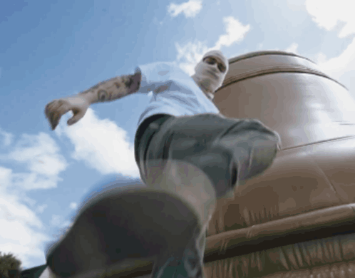 A Man Wearing A White Shirt And A Mask Is Walking GIF