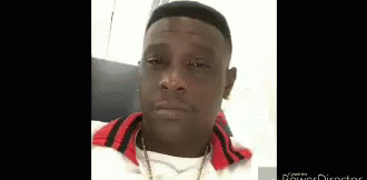 A Man Wearing A White Shirt And A Red Jacket Is Looking At The Camera . GIF