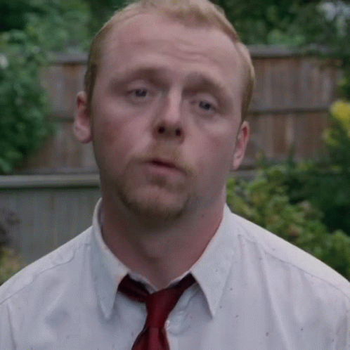 A Man Wearing A White Shirt And A Red Tie Looks At The Camera GIF