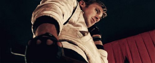 A Man Wearing A White Shirt And Black Gloves Looks Down GIF