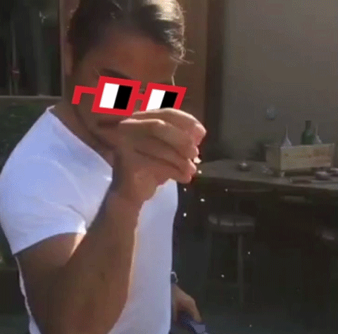 A Man Wearing A White Shirt And Red Sunglasses With The Letter H On The Lens GIF