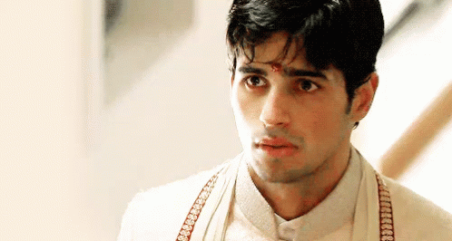 A Man Wearing A White Shirt And Suspenders Is Looking At The Camera With A Serious Look On His Face . GIF