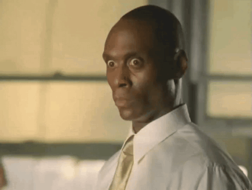 A Man Wearing A White Shirt And Tie Is Making A Funny Face . GIF