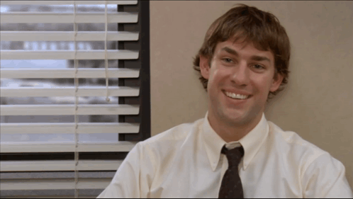 A Man Wearing A White Shirt And Tie Smiles In Front Of A Window GIF