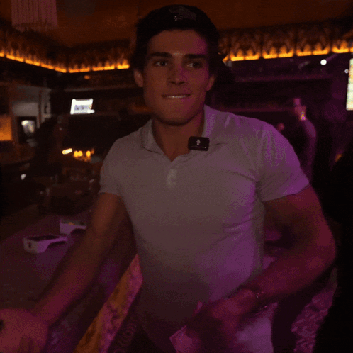 a man wearing a white shirt with a purple light behind him that says ' a ' on it