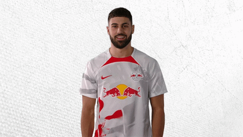 a man wearing a white shirt with a red bull on the front