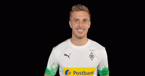 A Man Wearing A White Shirt With A Yellow Postbank Logo On It GIF