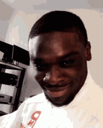 A Man Wearing A White Shirt With The Letter D On It Is Smiling GIF