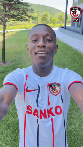 A Man Wearing A White Shirt With The Word Sanko On The Front GIF
