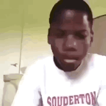 A Man Wearing A White Shirt With The Word Souderton On It . GIF