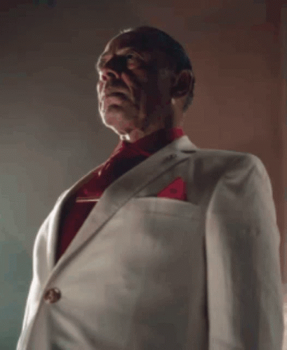 A Man Wearing A White Suit And Red Tie GIF