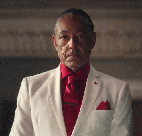 A Man Wearing A White Suit And Red Tie GIF
