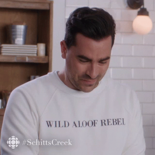 A Man Wearing A White Sweatshirt That Says Wild Aloof Rebel GIF