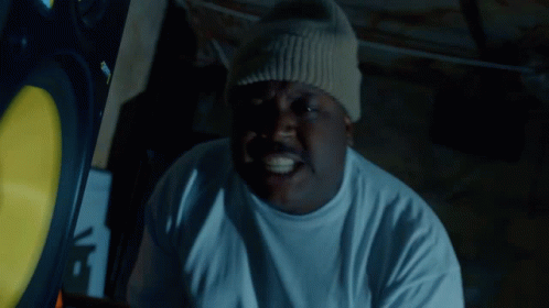 A Man Wearing A White T-Shirt And A Beanie Has A Sticker On His Hat That Says Supreme GIF