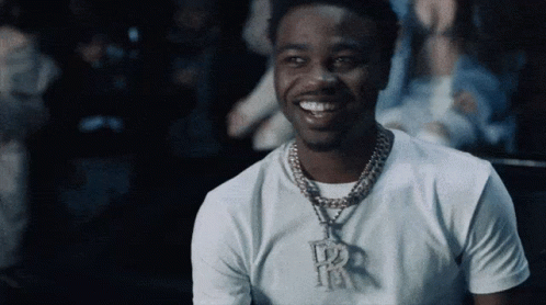 A Man Wearing A White T-Shirt And A Necklace With The Letter R On It GIF
