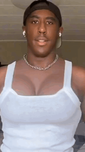 Man In White Tank Top, Hat, Necklace, Earbuds GIF