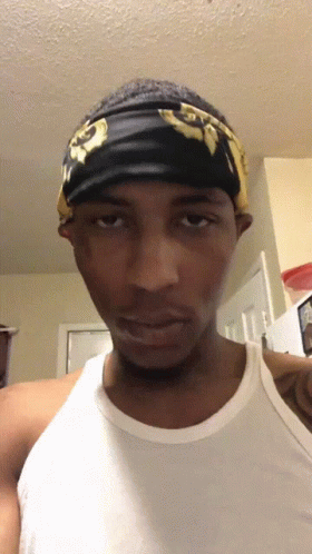 A Man Wearing A White Tank Top And A Black Headband GIF