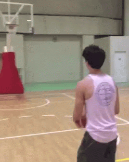 A Man Wearing A White Tank Top With A Basketball Logo On The Back Is Playing Basketball GIF