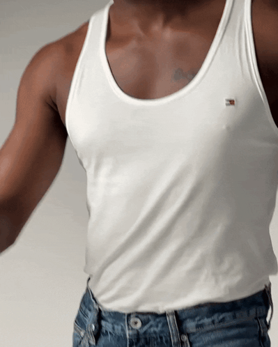 A Man Wearing A White Tank Top With A Tommy Hilfiger Logo On It GIF