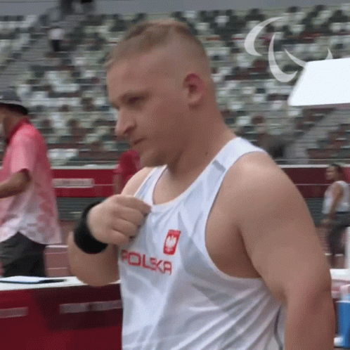A Man Wearing A White Tank Top With Polska On It GIF