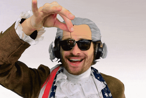 A Man Wearing A Wig And Headphones Is Holding A Cherry In His Hand GIF