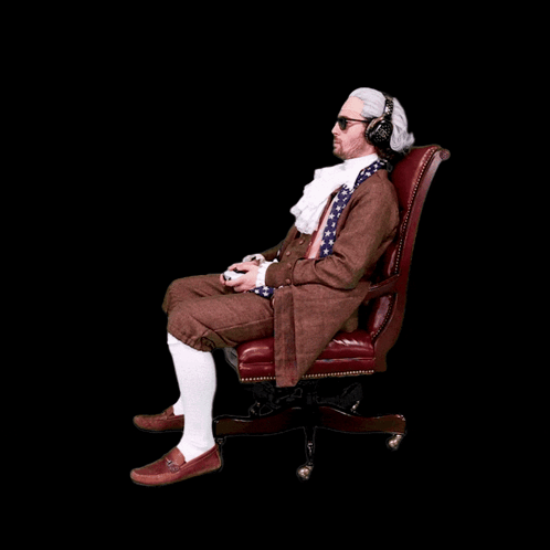 A Man Wearing A Wig And Headphones Is Sitting In An Office Chair Playing A Video Game GIF