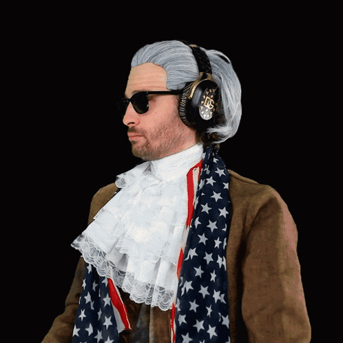 A Man Wearing A Wig And Headphones Is Wearing An American Flag Scarf Around His Neck GIF