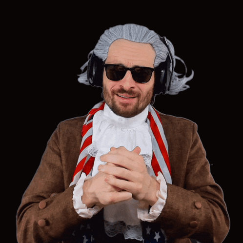 A Man Wearing A Wig And Sunglasses Has His Hands Folded In Front Of Him GIF