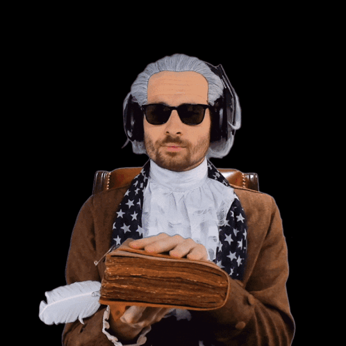 A Man Wearing A Wig And Sunglasses Is Holding A Book And A Feather GIF