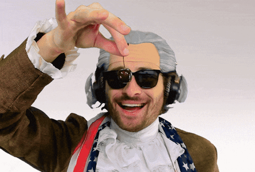 A Man Wearing A Wig And Sunglasses Is Holding A Cherry GIF