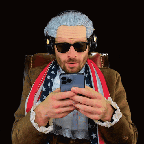 A Man Wearing A Wig And Sunglasses Is Looking At His Cell Phone GIF