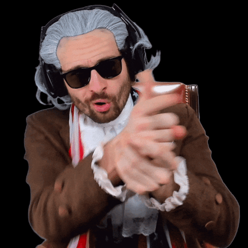 A Man Wearing A Wig And Sunglasses Is Making A Gesture With His Hands GIF
