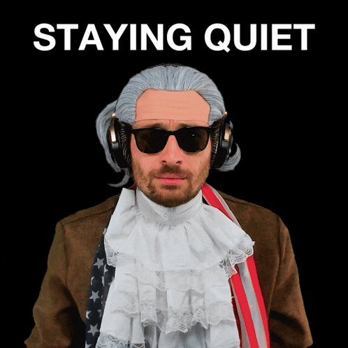 A Man Wearing A Wig And Sunglasses Stands In Front Of A Black Background That Says " Staying Quiet " GIF