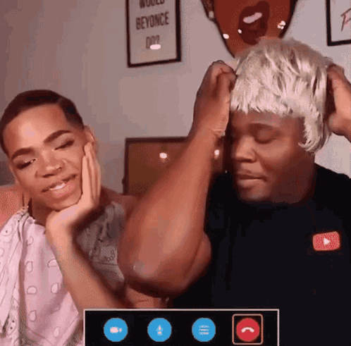 A Man Wearing A Wig Is Talking To Another Man GIF
