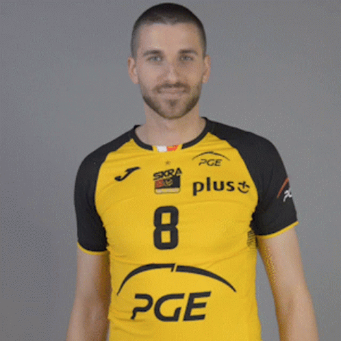 A Man Wearing A Yellow And Black Pge Plus Shirt GIF