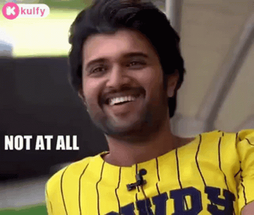 Man Smiling In Yellow And Black Striped Shirt Says Not At All GIF