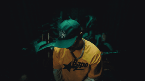 A Man Wearing A Yellow Bape Shirt And Sunglasses GIF