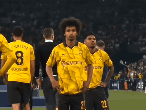 a man wearing a yellow evonk jersey stands in front of a crowd