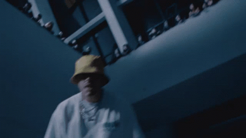 A Man Wearing A Yellow Hat And A White Shirt With The Word Adidas On It Is Dancing In Front Of A Crowd GIF