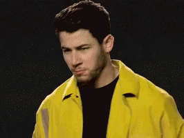 A Man Wearing A Yellow Jacket And A Black Shirt GIF