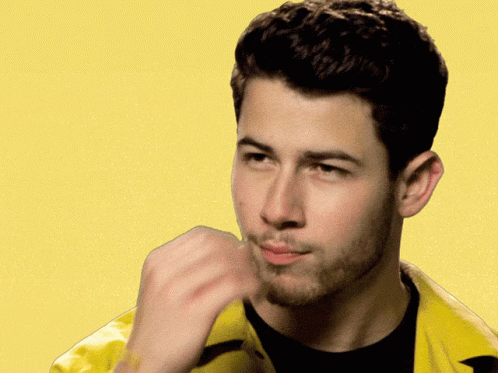 A Man Wearing A Yellow Jacket And A Black Shirt Is Making A Funny Face GIF